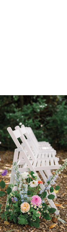 A white chair with a flower arrangement in it. Description generated by AI