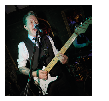 A man wearing a tie and holding a guitar. Description generated by AI