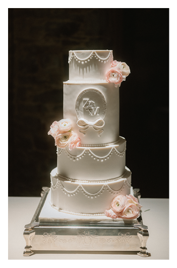 A three-tiered white cake with pink roses on top. Description generated by AI