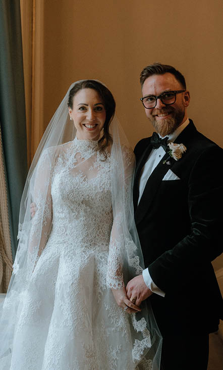 A bride and groom pose for a picture. Description generated by AI