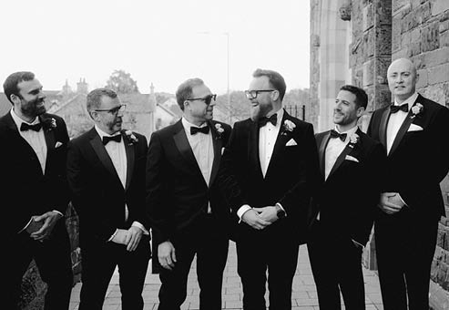 A group of men wearing suits and ties. Description generated by AI