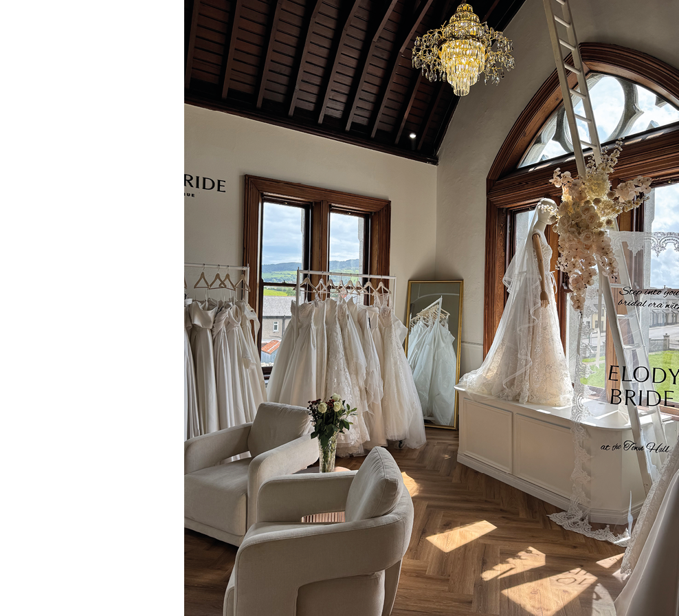 A white room with a large chandelier and a white couch. Description generated by AI