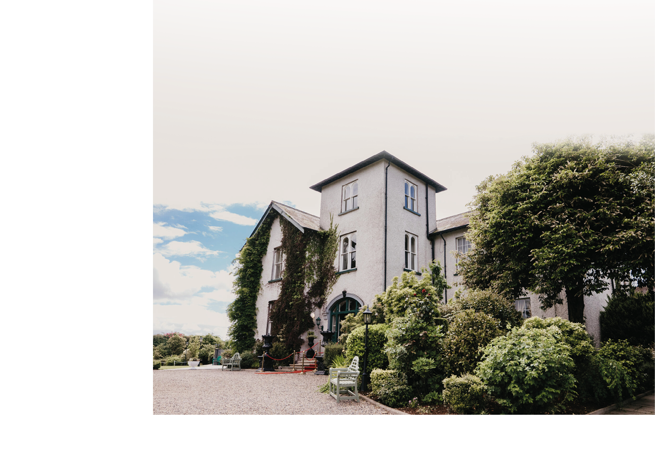 A large white house with a green roof. Description generated by AI