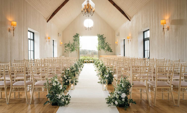 A church with a long aisle and rows of chairs. Description generated by AI