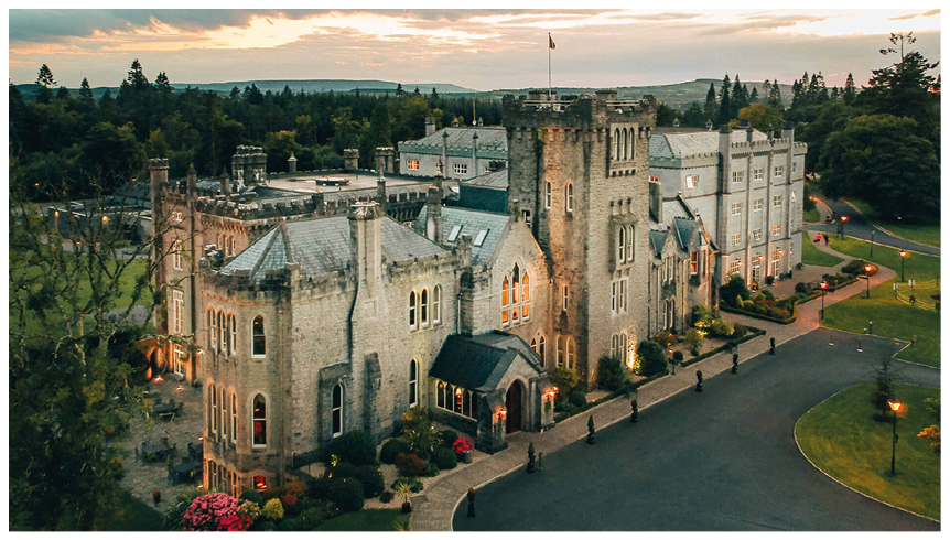 A large castle with a black roof and a flag on top. Description generated by AI