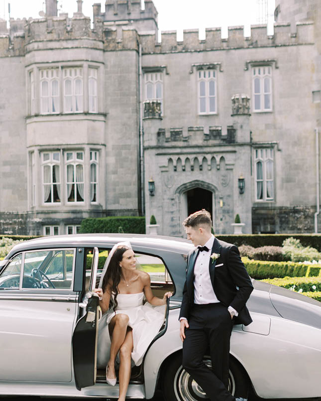 A man and woman are standing next to a car. Description generated by AI