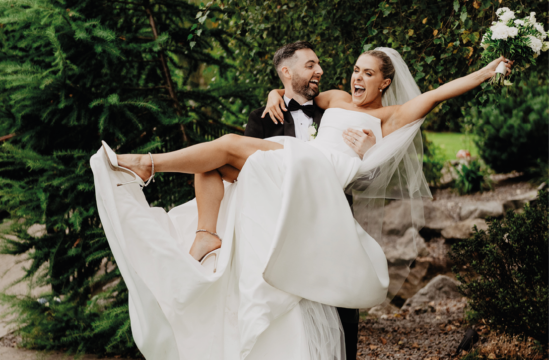 A bride and groom are dancing in the grass. Description generated by AI