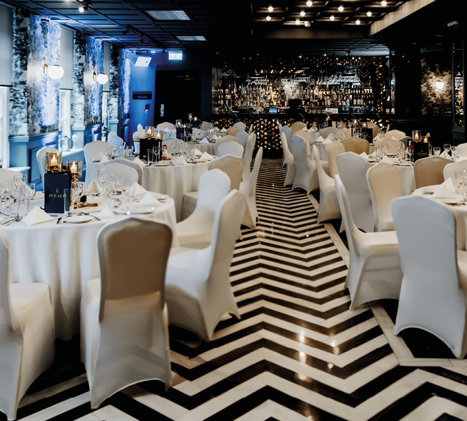 A black and white checkered floor with white chairs and tables. Description generated by AI