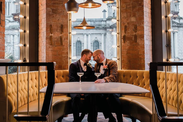 A man and woman sitting at a table in a restaurant. Description generated by AI