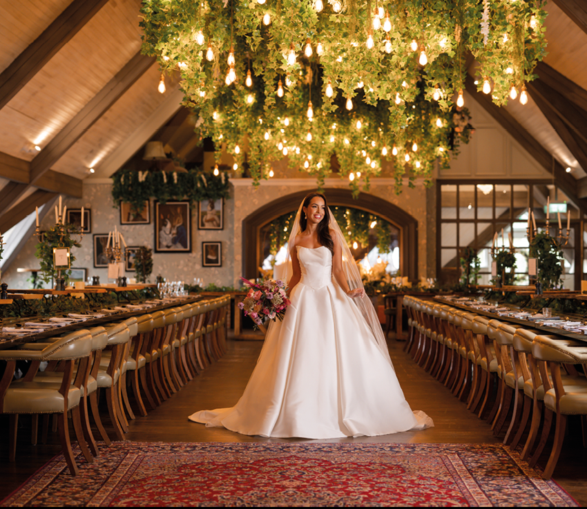 A woman in a white wedding dress standing in a room with a red carpet. Description generated by AI