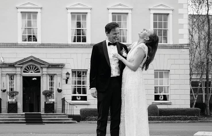 A man and woman standing on a staircase in front of a building. Description generated by AI