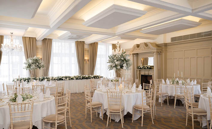 The room is filled with tables and chairs. Description generated by AI