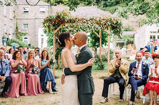 A bride and groom are dancing in front of a crowd of people. Description generated by AI