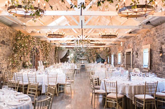 A large room with a long table set for a wedding reception. Description generated by AI