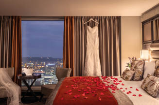 A bed with red rose petals on it. Description generated by AI
