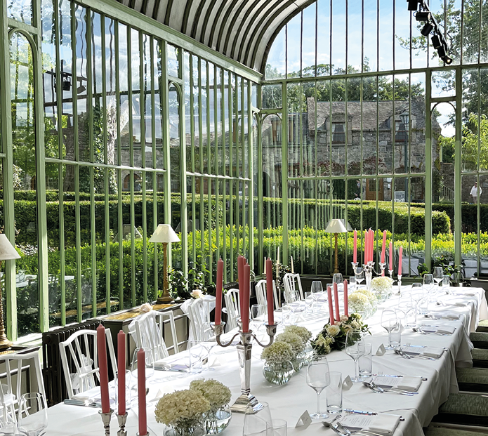 A large glass table with a white tablecloth and red candles. Description generated by AI