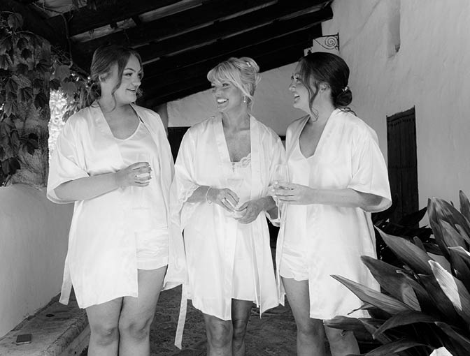 Three women standing on a porch. Description generated by AI