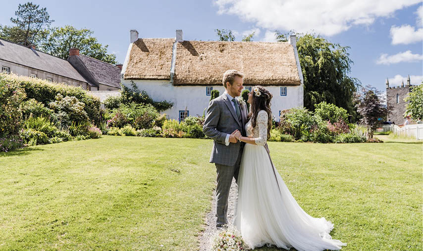 A bride and groom are standing in a field. Description generated by AI