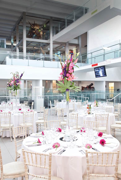 A large room with a long table set for a banquet. Description generated by AI
