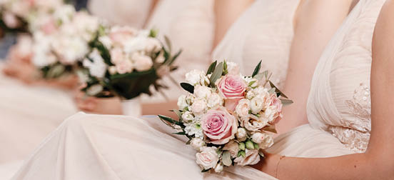 close up of nude bridesmaids dresses, flower bouquets, modern and trendy gowns sitting on wedding ceremony. wedding day. High quality photo.