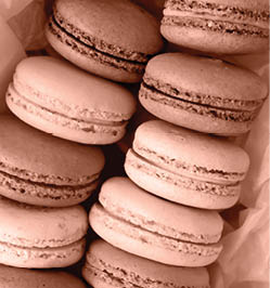 Colorful macarons in craft packaging on a light wooden background. Color of the Year Mocha Mousse.