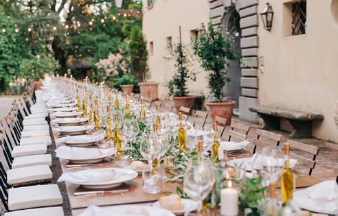 Wedding dinner decor in an elegant villa. a long rectangular table decorated with flowers, greenery and candles. Wedding banquet in white and yellow colors