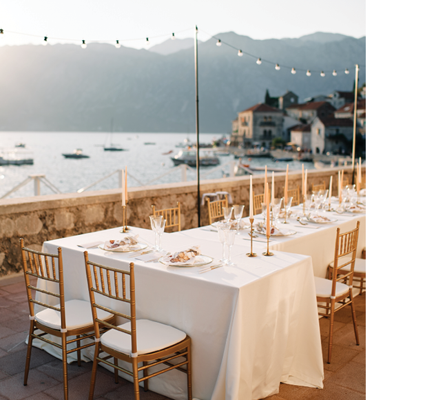 Covered festive tables stand on the terrace by the sea