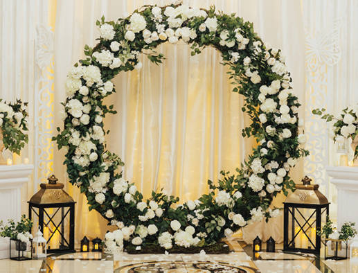 Wedding arch at the restaurant. Round flower arch. Trend in the wedding banquet room is a white arch decorated with flowers and greens, in the background white cloth.