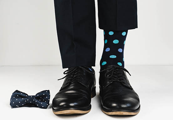 Stylish black shoes, bright, happy socks and a beautiful bow tie on a white background. Style, fashion, beauty