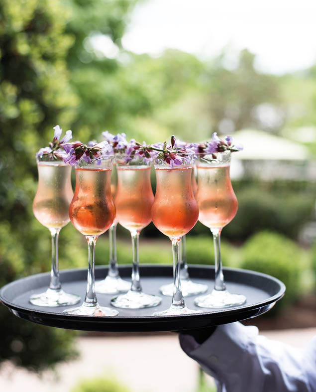 Tray of beautiful cocktails with flower garnishes 