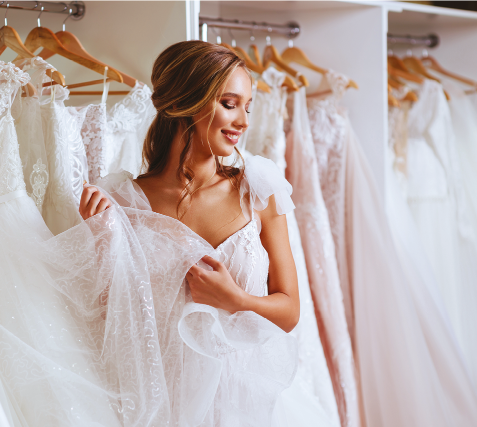 Beautiful bride is trying on an elegant wedding dress in modern wedding salon