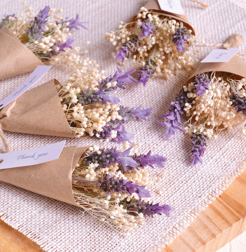 Wedding favours lavender mini bouquet with small flowers, thank you party souvenir original gifts for guests, diy handmade present on rustic favor table witn jute wood background, purple white color