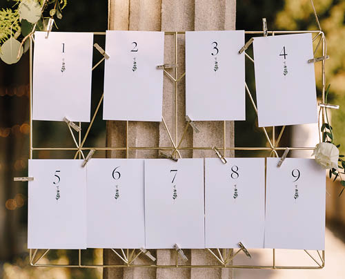 Seating plan. Numbered blank cards on a metal wicker stand hang on a column. Inscription: 1, 2, 3, 4, 5, 6, 7, 8, 9