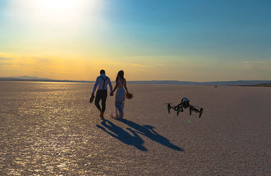 Luxury and futuristic wedding photography and videography. Hovering drone taking pictures of wedding couple at Salt Lake, Sereflikochisar, Turkey.