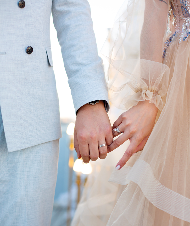 Close-up photo of the men`s holding woman hand with golden wedding ring with diamond. Wedding ring before the proposal. Luxury wedding rings