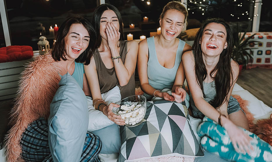 Cheerful girls looking at comedy with pleasure at home. They laughing. Happy concept