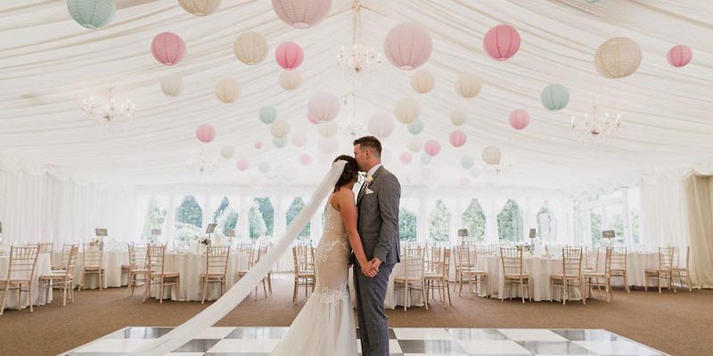 wedding couple in marquee decorated with lanterns