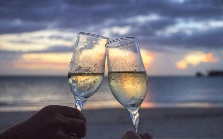 wine glasses clinking on beach