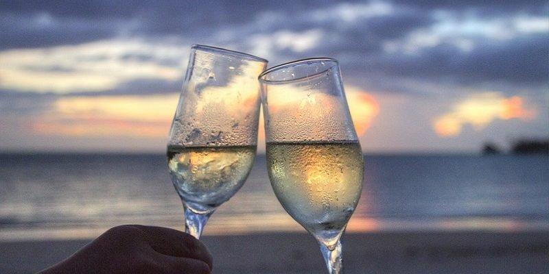 wine glasses clinking on beach