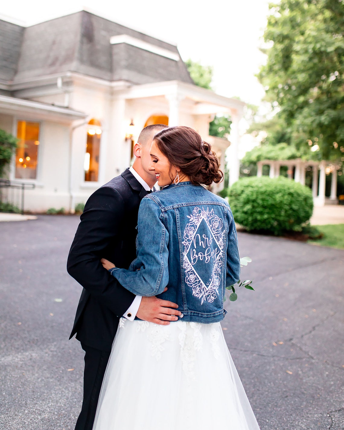 This image shows a bride and groom. The bride is wearing a customised denim jacket.