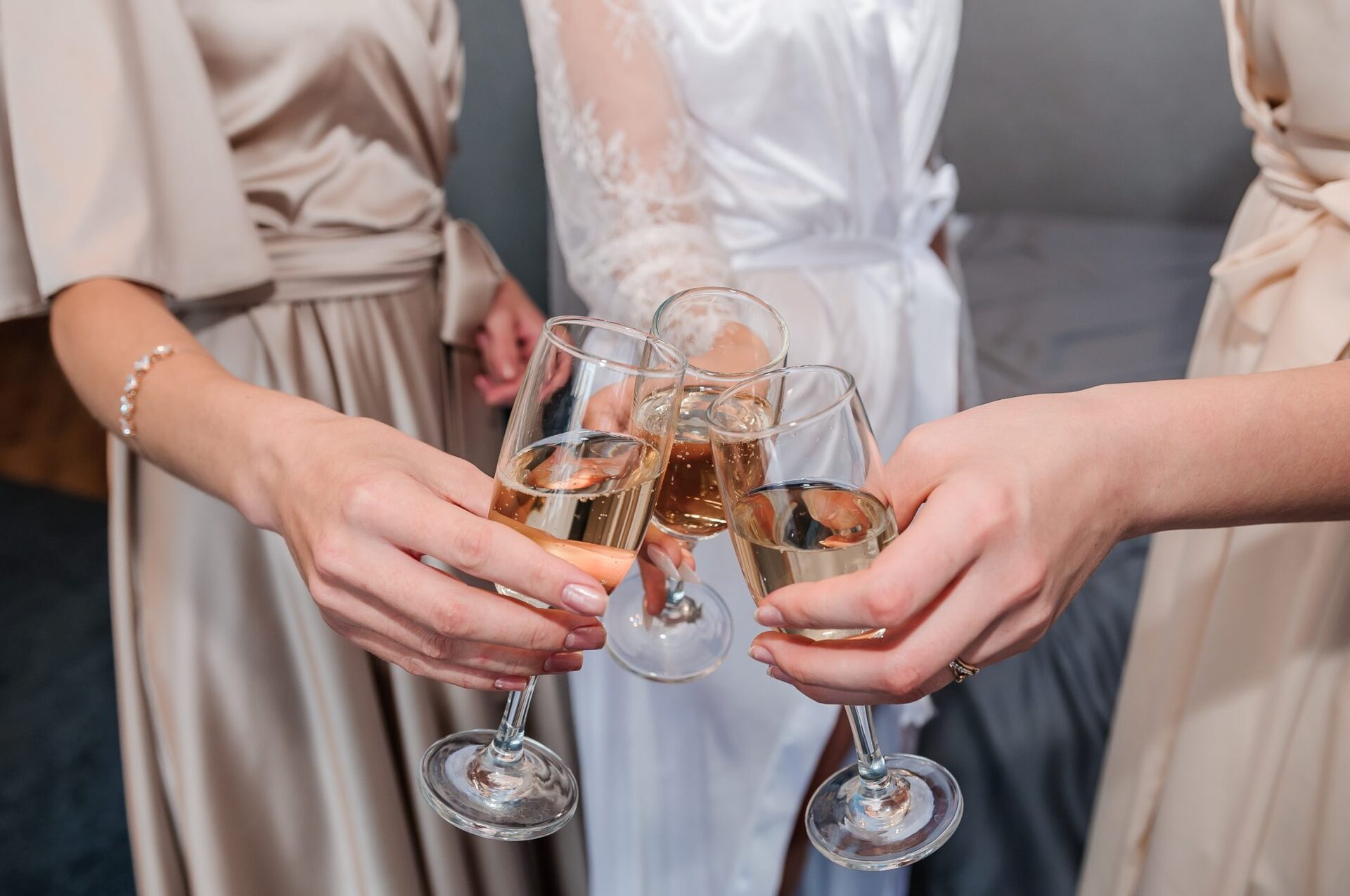 3 champagne glasses a held together in a cheers pose.