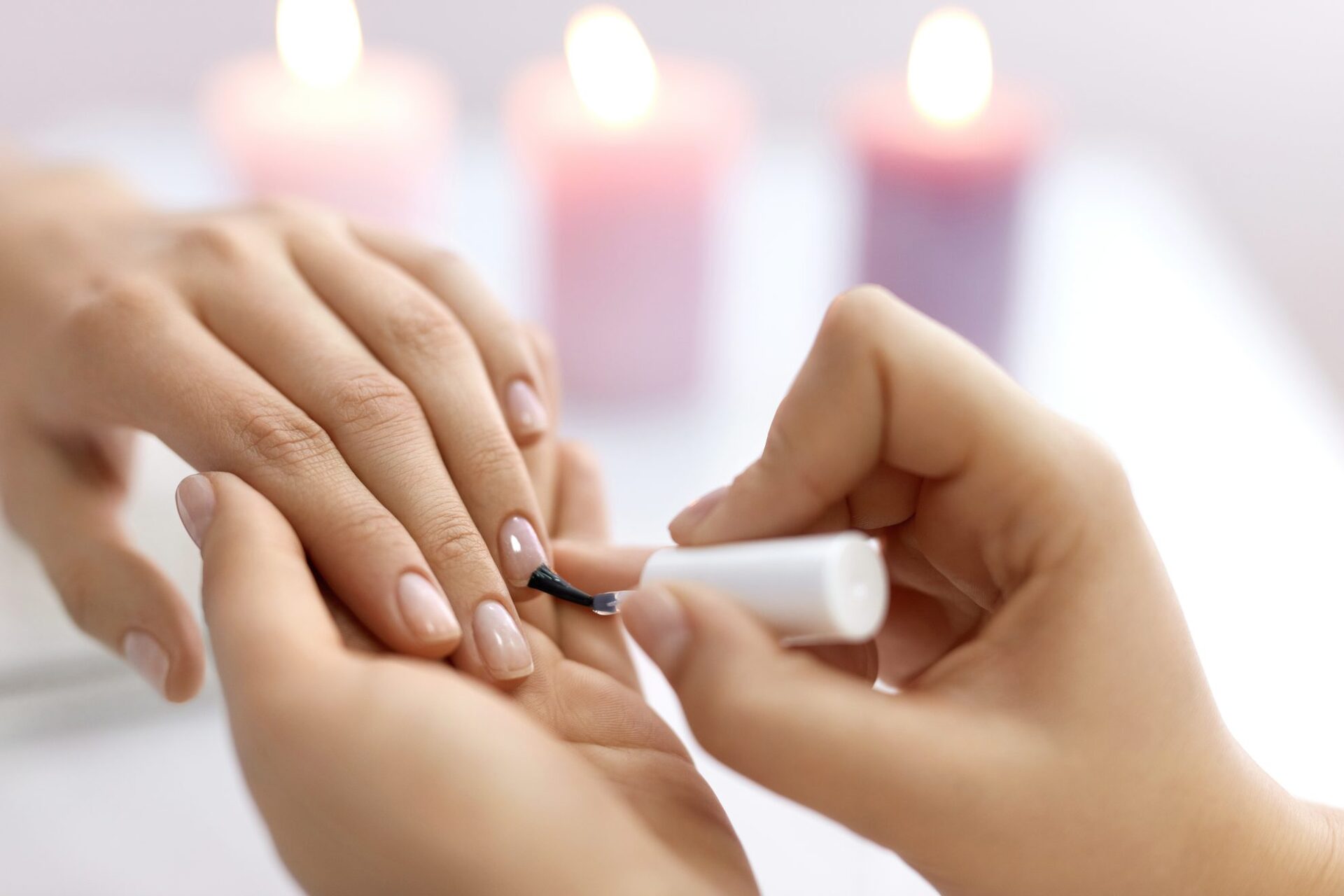 Close-up on a woman's hand as she is getting a manicure.