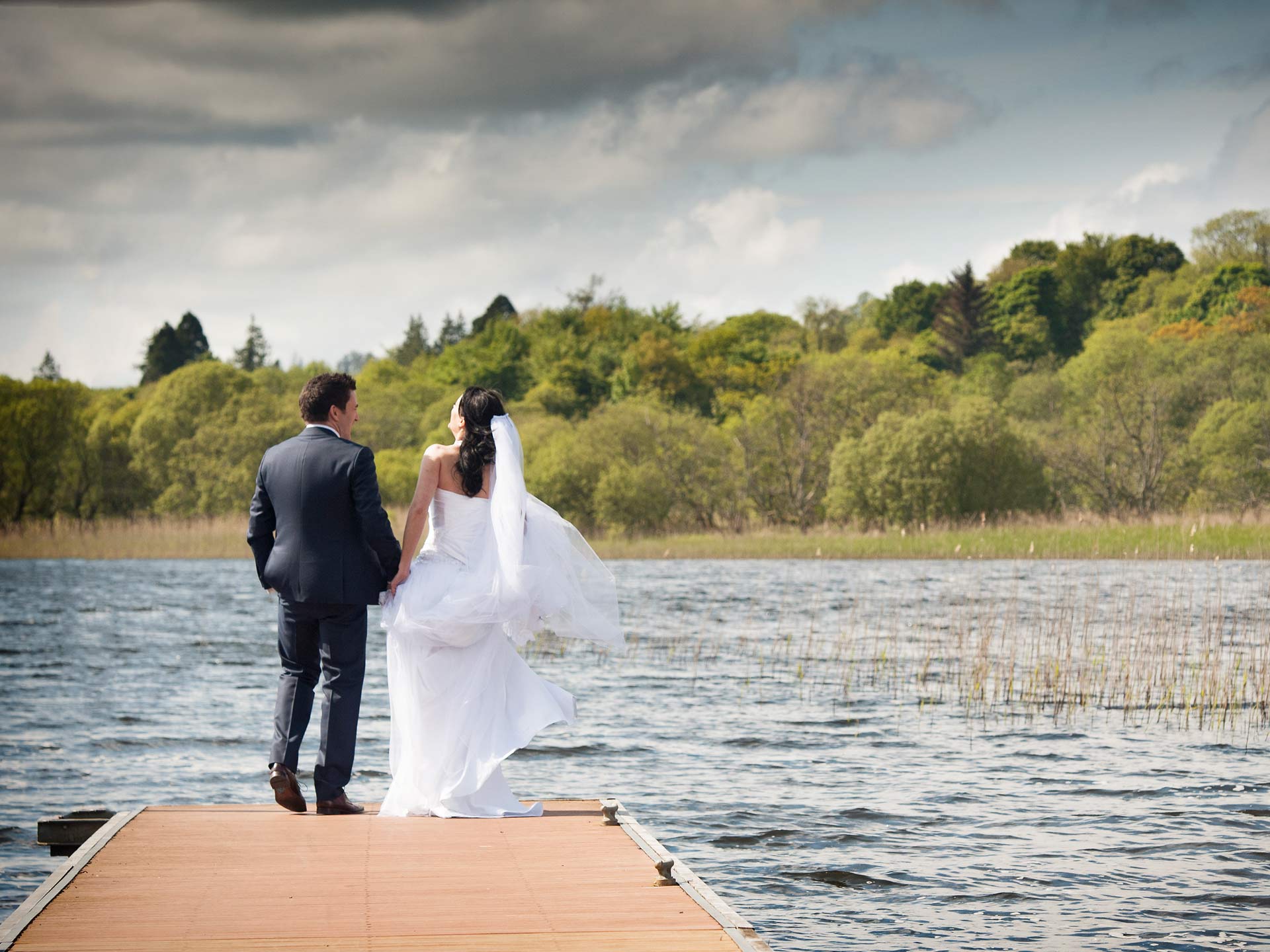 Bride and groom on pier. Image used in the Outdoor Wedding Venues In Ireland for Spring / Summer article.