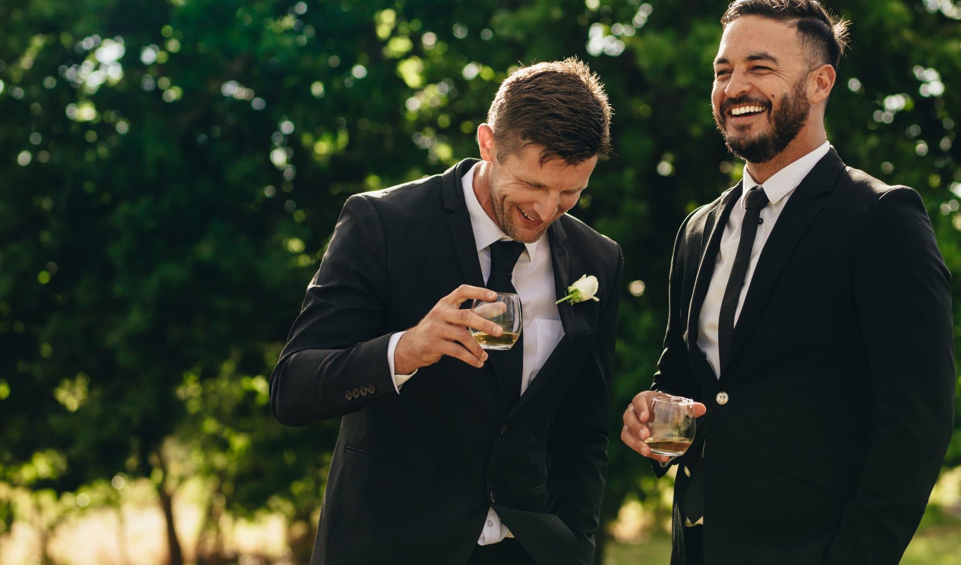 A groom and best man standing together laughing. Image used in the How To Write The Perfect Best Man Speech and Nail It article.