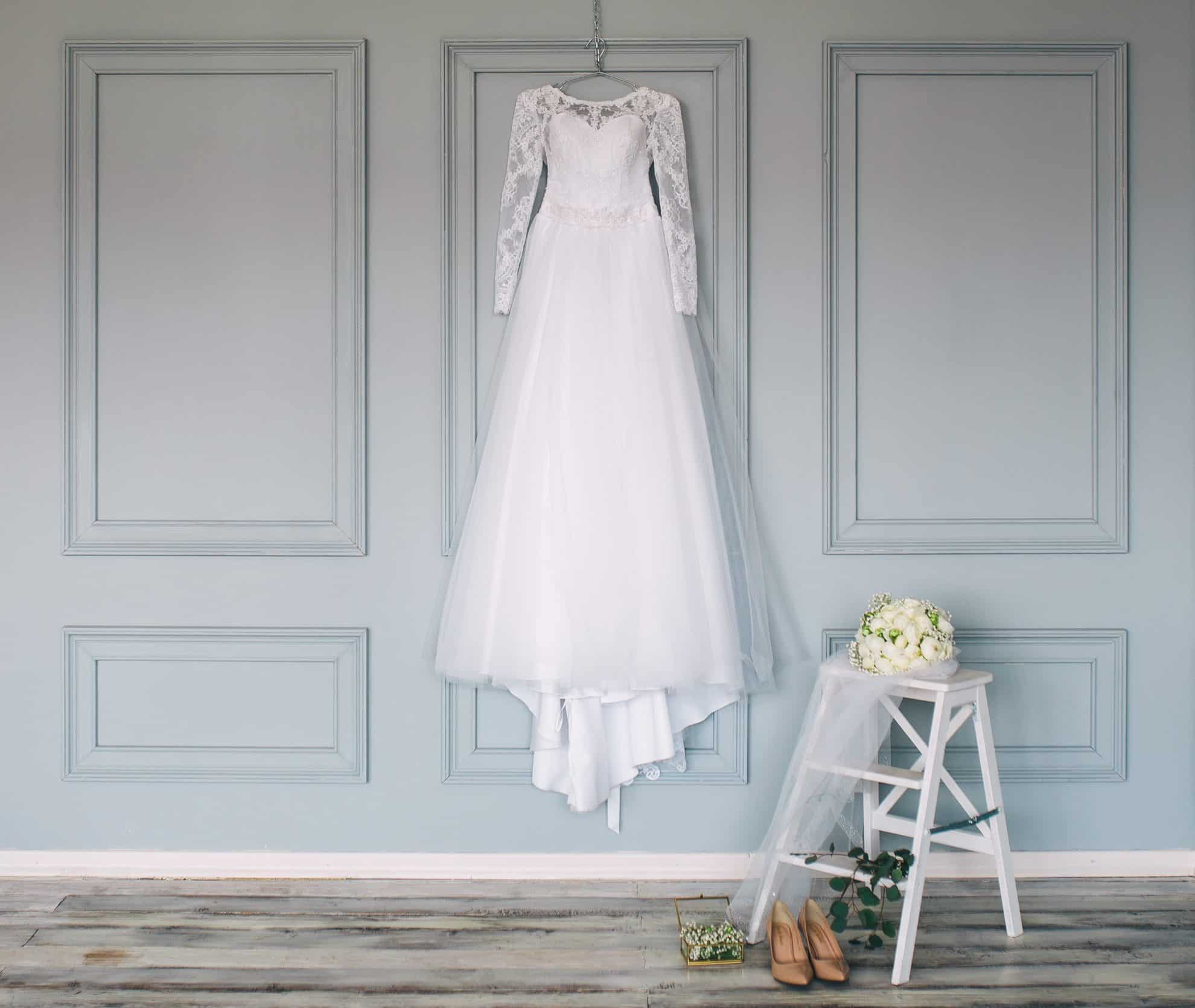 What To Include In Your Wedding Overnight Bag - wedding dress hanging  up