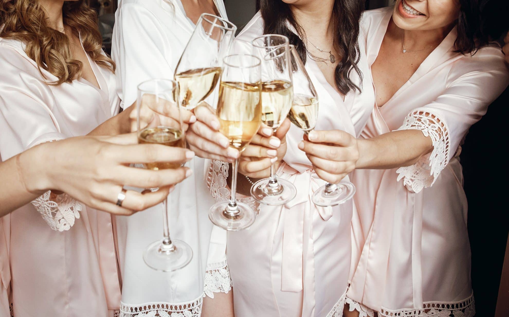 What To Include In Your Wedding Overnight Bag - bridal party with bubbly
