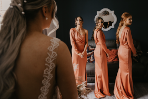 Bride giving bridesmaids first look at her dress