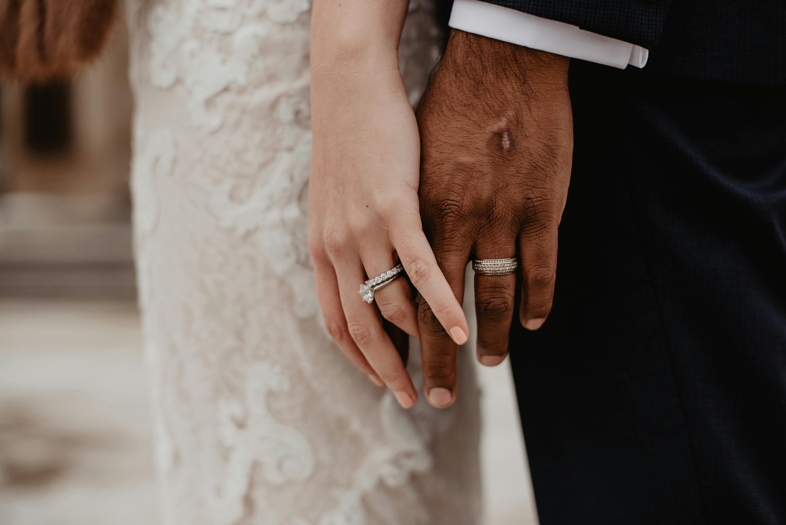 Mens wedding band holding hands with bride